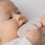 תינוקת נושכת נשכן סיליקון לתינוקות להקלה על בקיעת שיניים ירח ורוד